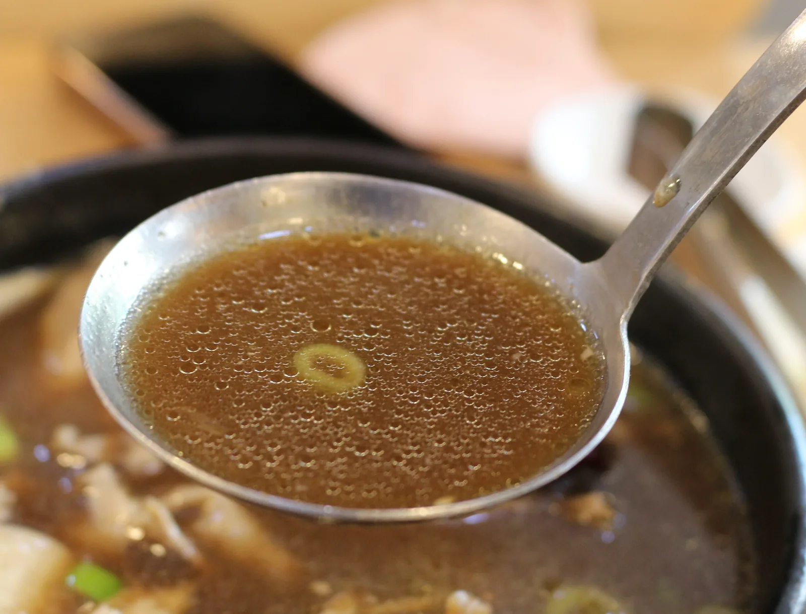 국자로 떠 올린 맑은 갈색 한방 육수