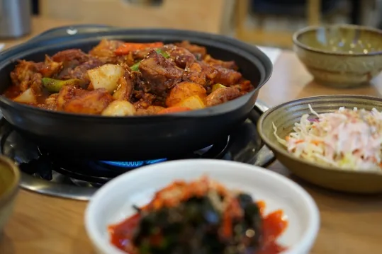 가스불 위 볶음탕 냄비와 반찬 그릇